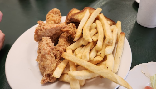 A plate of crispy fried chicken pieces alongside golden French fries.